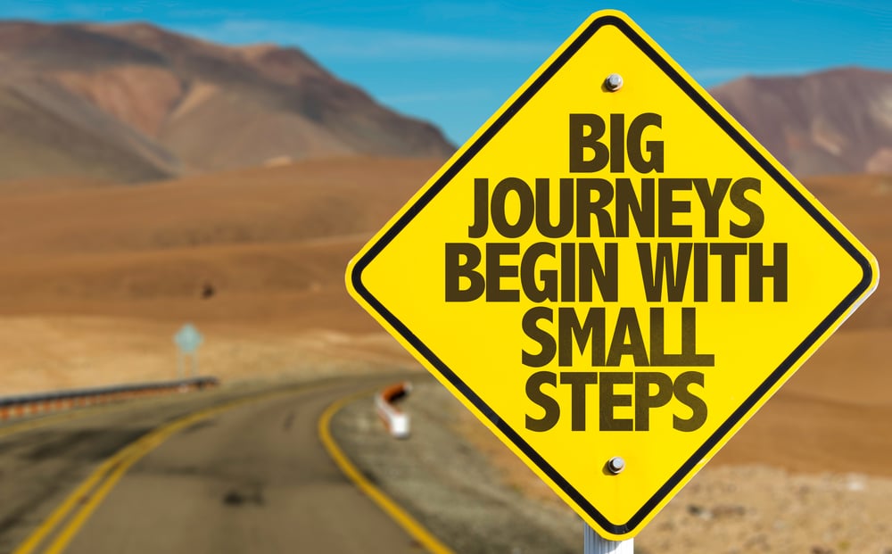 Big Journeys Begin With Small Steps sign on desert road