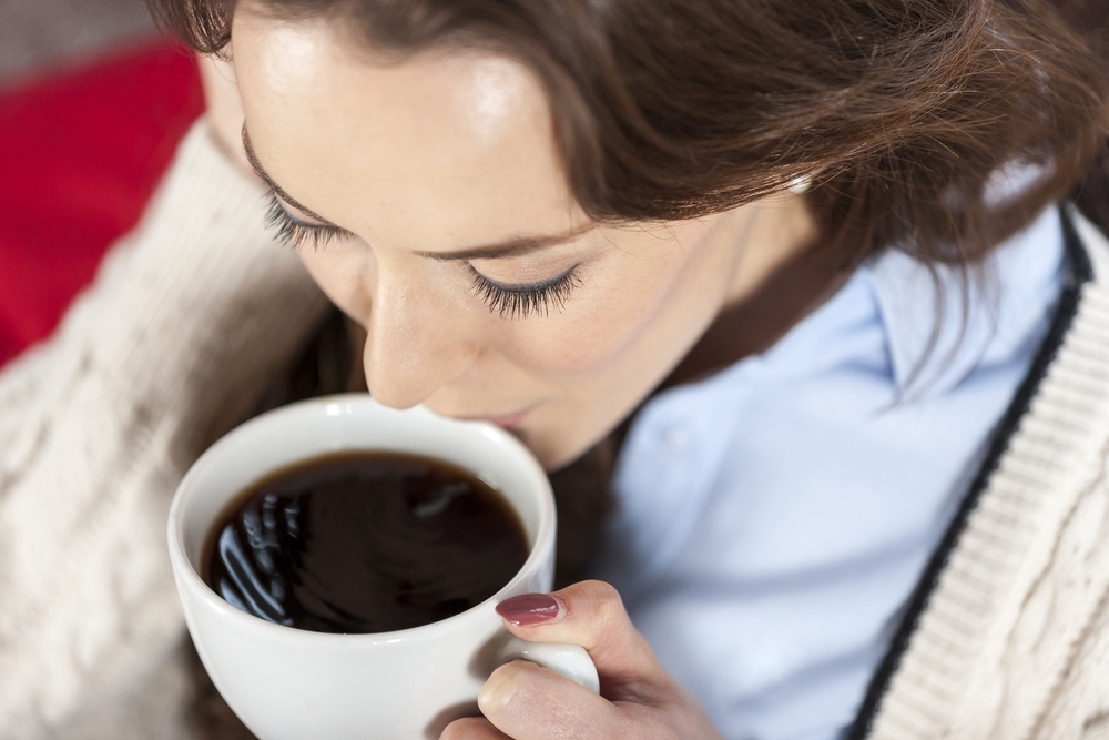 Beautiful young woman enjoying a fresh cup of coffee in a coffee shop