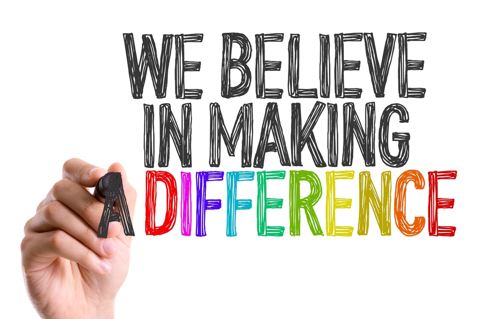 Hand with marker writing We Believe in Making a Difference