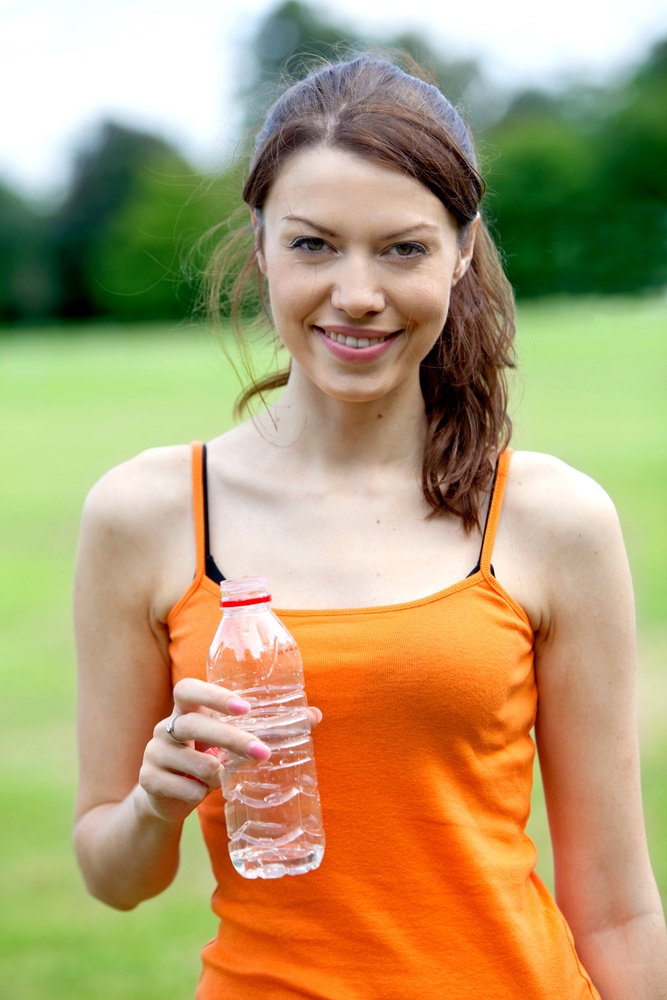 beautiful woman drinking water after finishing her running session